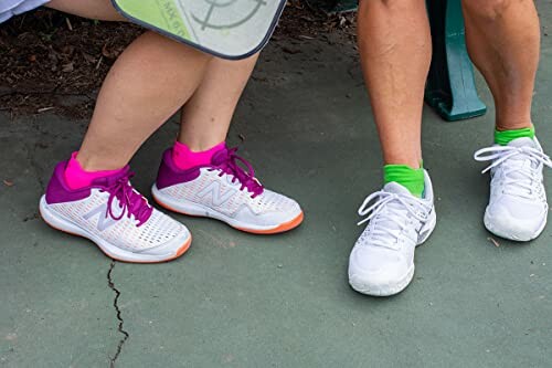 Two people wearing athletic shoes with a pickleball paddle.